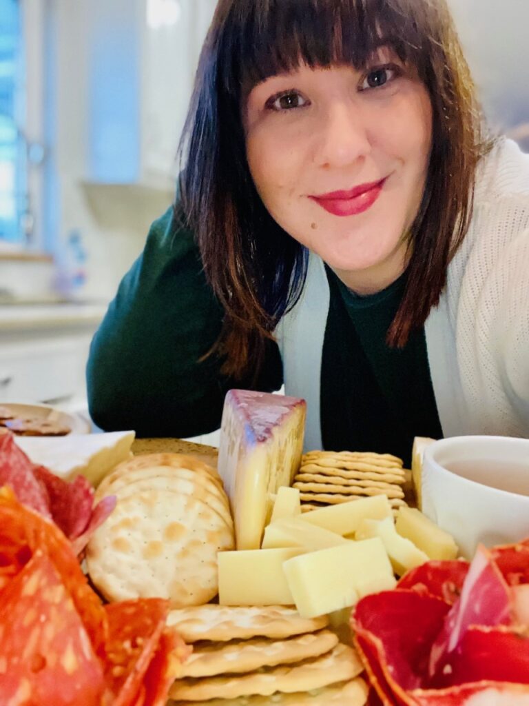 Women with cheese and crackers platter.